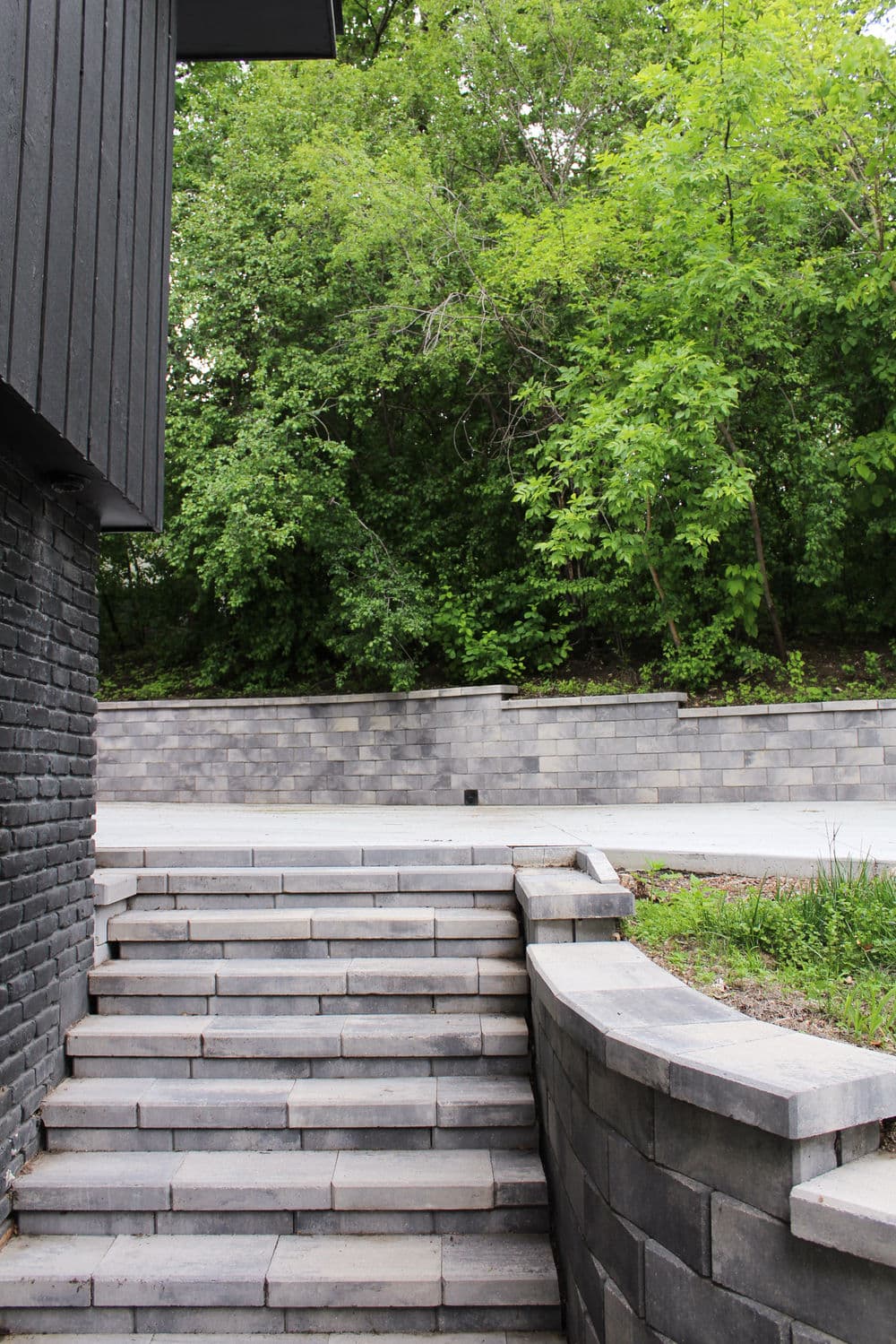 Stone stairs leading to a lush green landscape with trees and a stone wall.